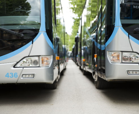 closeup of two large dallas charter buses parked in a lot